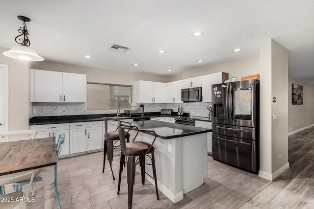 kitchen with white cabinetry, electric range, fridge with ice dispenser, and visible vents