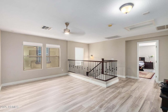 unfurnished room with light wood-style flooring, baseboards, and visible vents