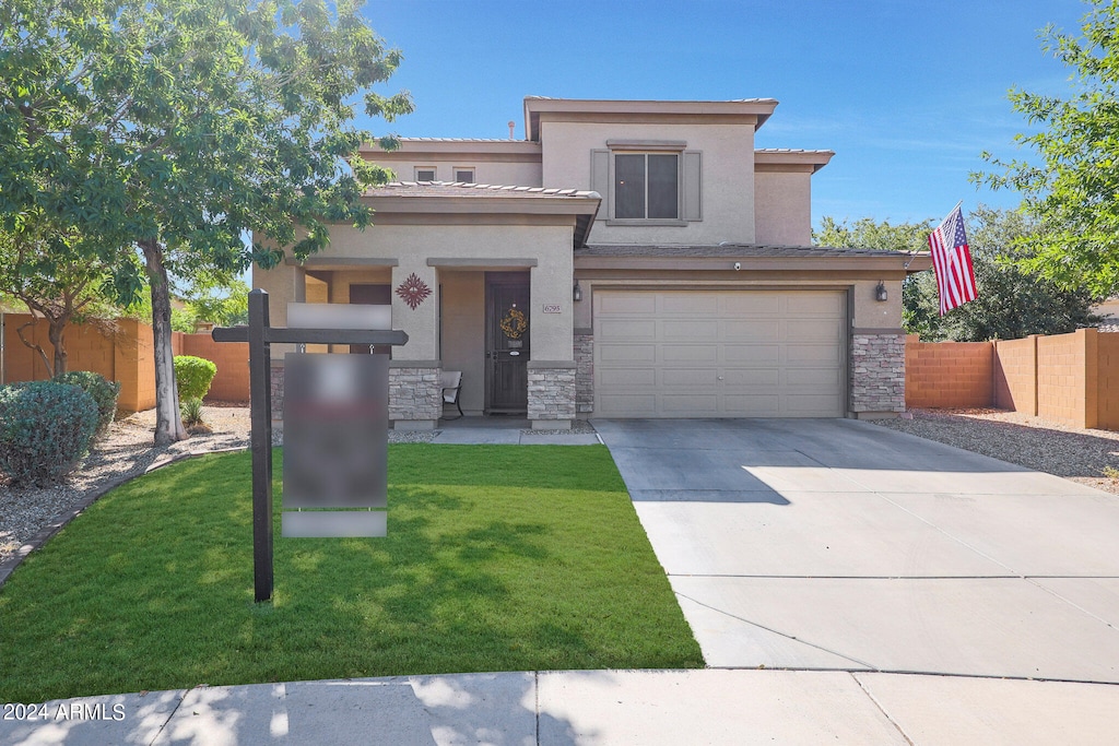 view of front of home with a front yard and a garage