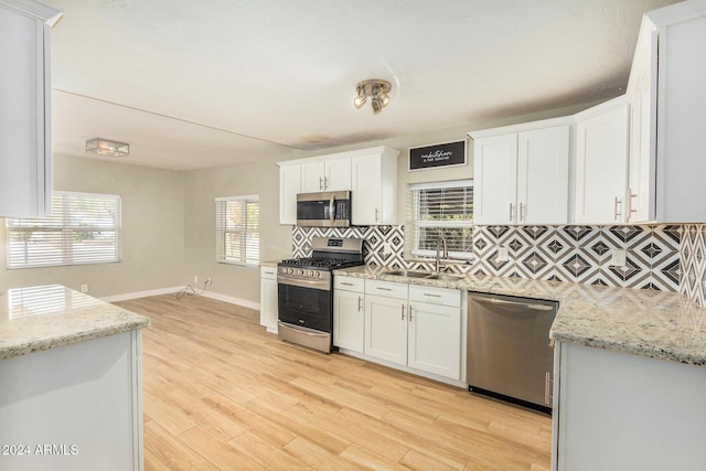 kitchen featuring light stone countertops, sink, white cabinets, and appliances with stainless steel finishes