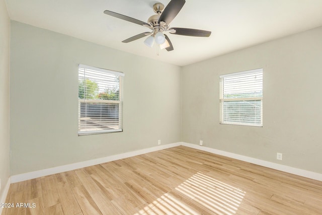 spare room featuring ceiling fan, light wood-type flooring, and a wealth of natural light