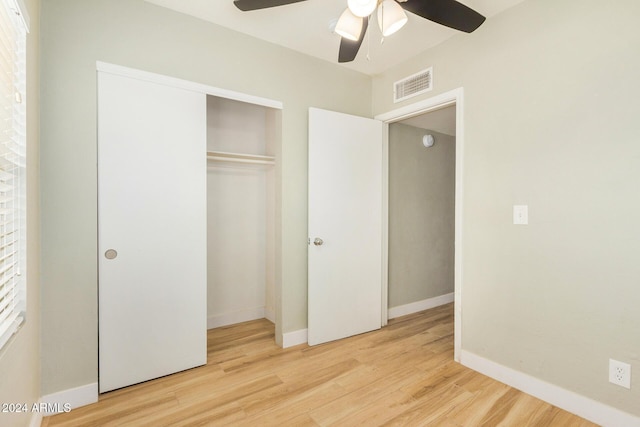 unfurnished bedroom featuring ceiling fan, a closet, and light wood-type flooring