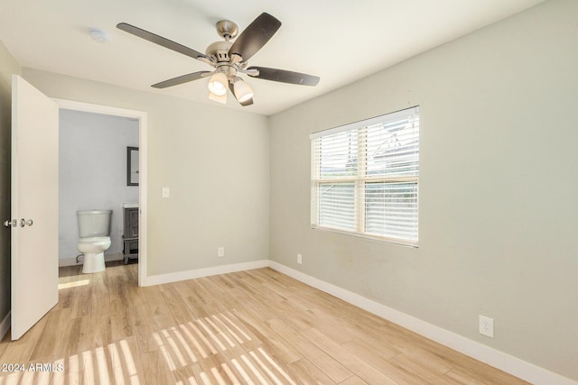 unfurnished bedroom with connected bathroom, light hardwood / wood-style flooring, and ceiling fan