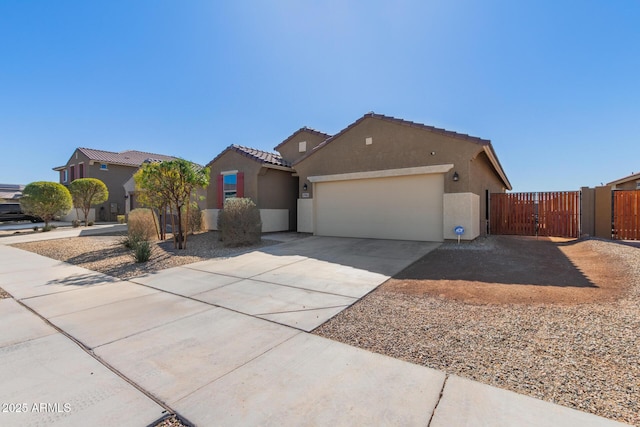 view of front of home with a gate, a tiled roof, concrete driveway, and stucco siding