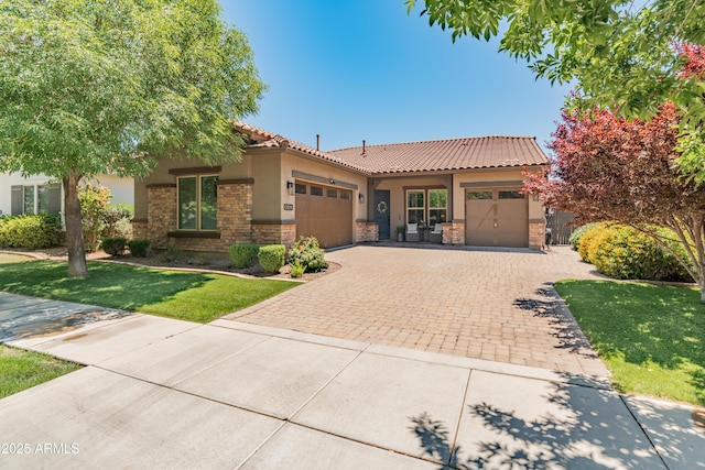 view of front facade featuring an attached garage, stone siding, stucco siding, a tiled roof, and decorative driveway