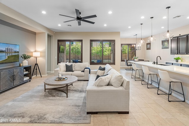 living area with recessed lighting, healthy amount of natural light, ceiling fan, light tile patterned floors, and baseboards