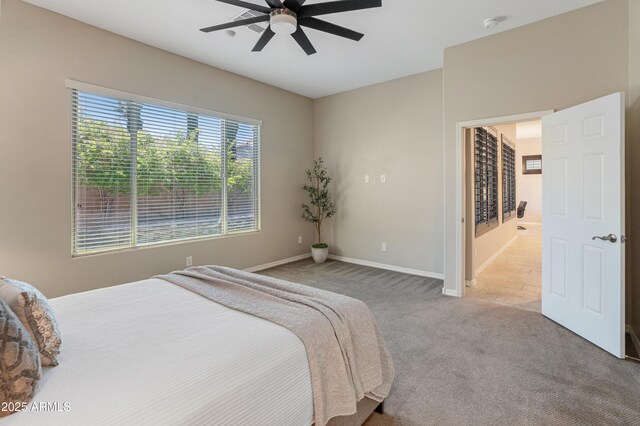 bedroom featuring carpet, baseboards, a ceiling fan, and ensuite bath