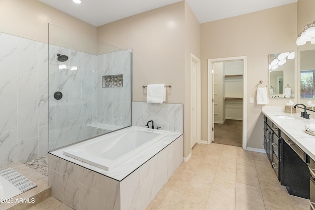 full bathroom with a garden tub, walk in shower, vanity, a spacious closet, and tile patterned floors
