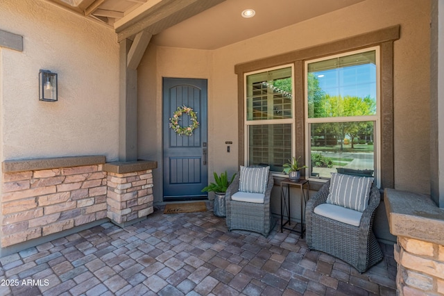doorway to property with stucco siding and covered porch