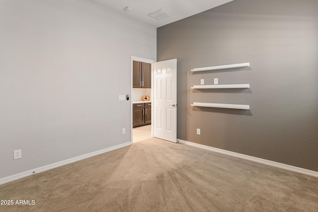 unfurnished room with light colored carpet and baseboards