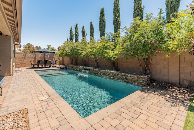 view of swimming pool featuring a fenced backyard, a patio area, and outdoor dining space