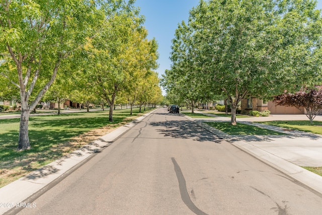 view of asphalt street featuring curbs
