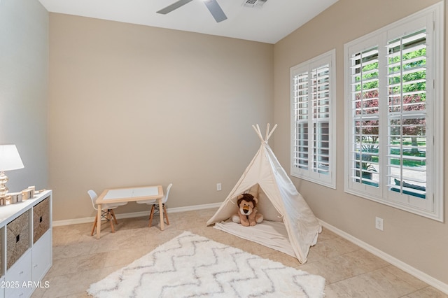 recreation room featuring ceiling fan, light tile patterned flooring, and baseboards