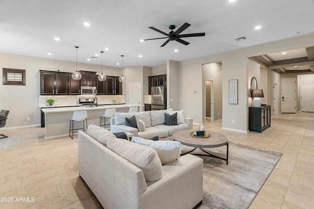 living room featuring a ceiling fan, recessed lighting, and baseboards