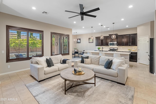 living area with recessed lighting, ceiling fan, baseboards, and light tile patterned floors