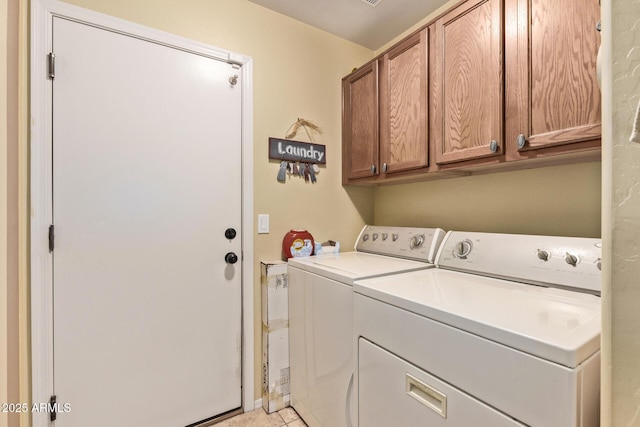 laundry area with cabinets, washer and dryer, and light tile patterned floors