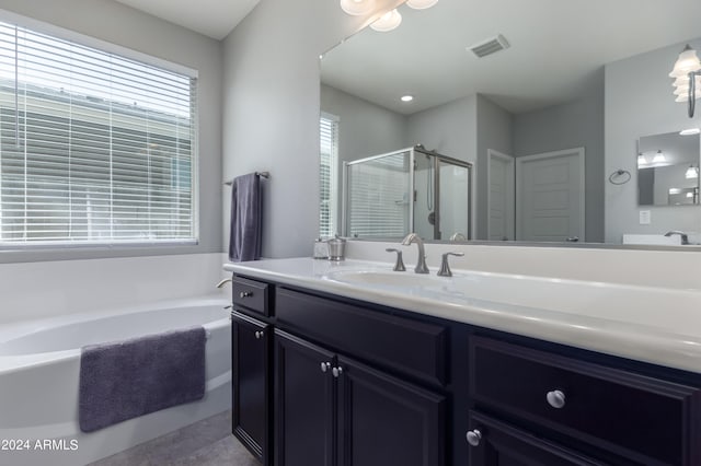 bathroom with tile flooring, vanity, and plus walk in shower