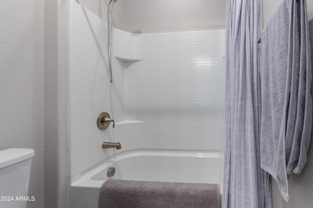 bathroom with shower / tub combo and toilet