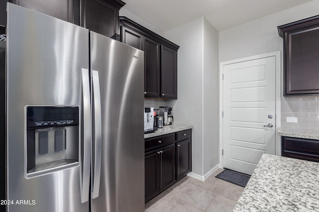 kitchen featuring tasteful backsplash, stainless steel fridge, light tile floors, and dark brown cabinetry