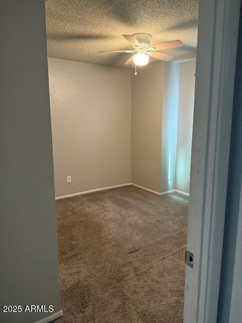 empty room featuring ceiling fan, a textured ceiling, baseboards, and carpet flooring