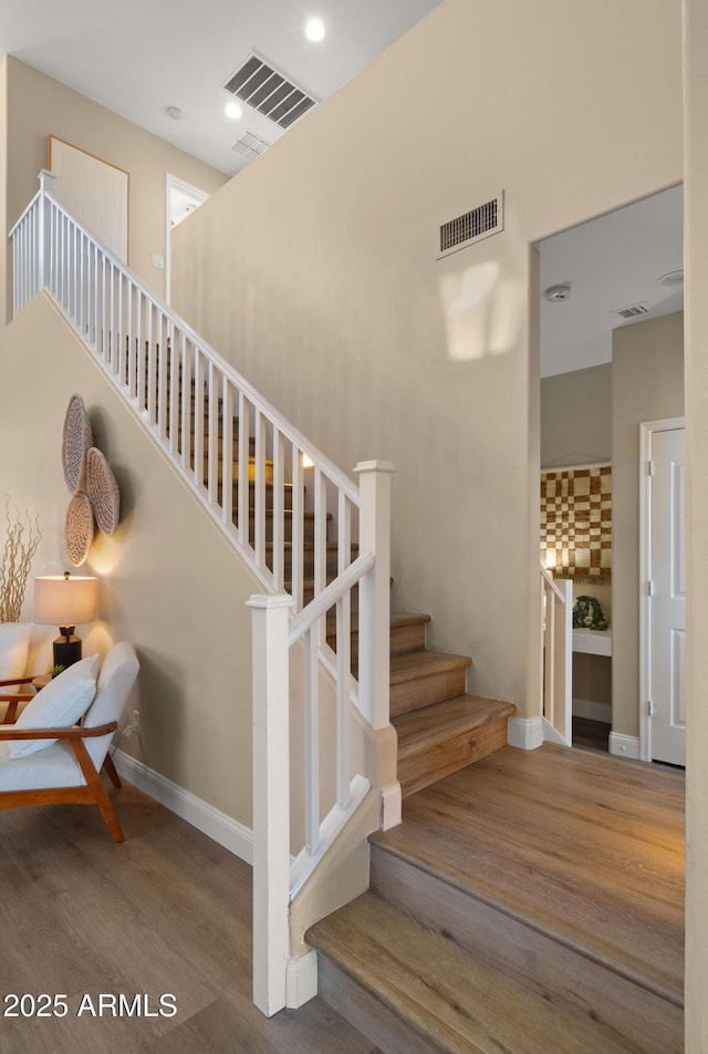 stairs featuring recessed lighting, visible vents, baseboards, and wood finished floors