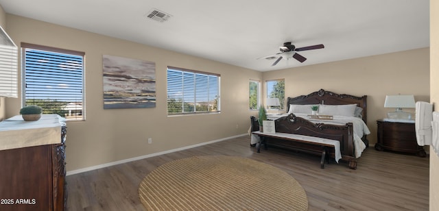 bedroom featuring multiple windows, wood finished floors, visible vents, and baseboards