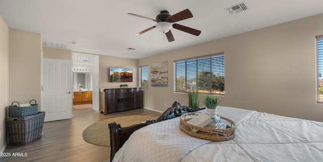 bedroom featuring light wood finished floors, visible vents, and baseboards