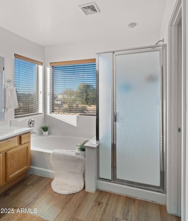 full bathroom featuring a shower stall, visible vents, wood finished floors, and vanity