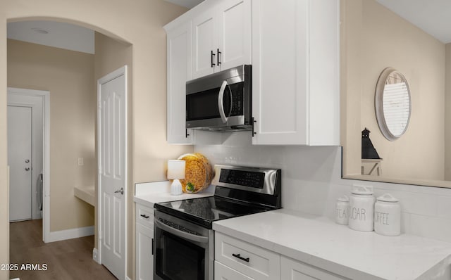 kitchen featuring appliances with stainless steel finishes, white cabinets, and decorative backsplash