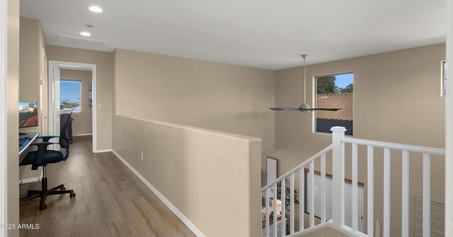 corridor with recessed lighting, baseboards, an upstairs landing, and wood finished floors