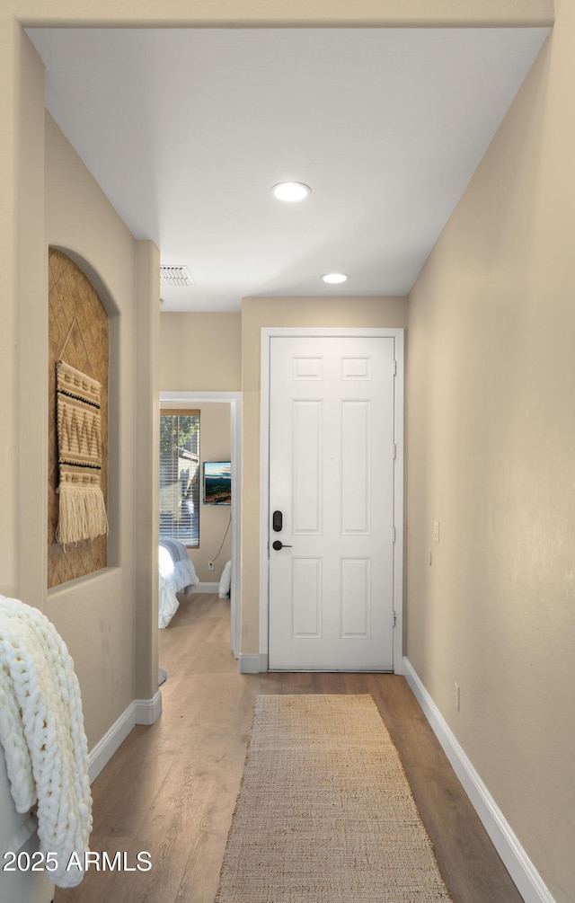 interior space featuring light wood-type flooring, baseboards, visible vents, and recessed lighting