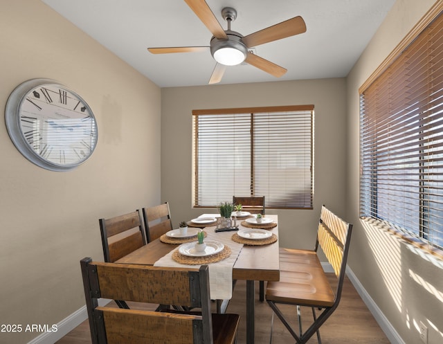 dining room with a ceiling fan, baseboards, and wood finished floors