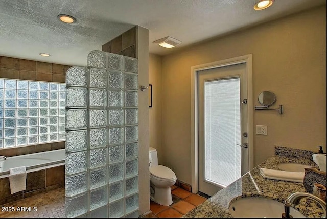 full bath with walk in shower, a sink, tile patterned flooring, a textured ceiling, and toilet