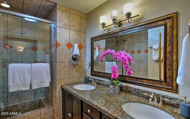 bathroom with double vanity, a stall shower, and a sink