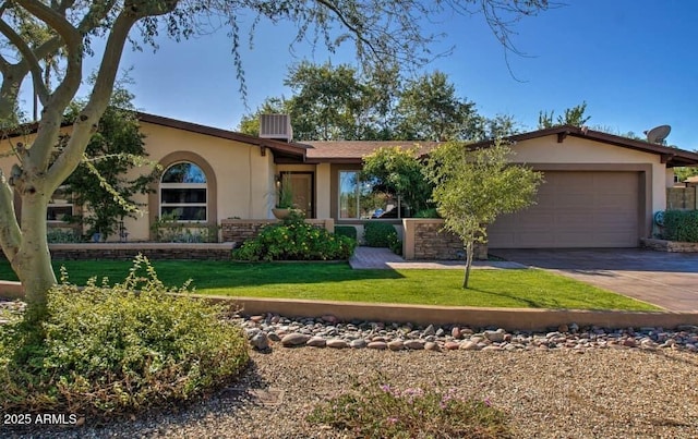 view of front of home with stucco siding, a front yard, an attached garage, and driveway