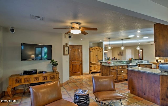 kitchen featuring light tile patterned floors, visible vents, a peninsula, ceiling fan, and decorative light fixtures