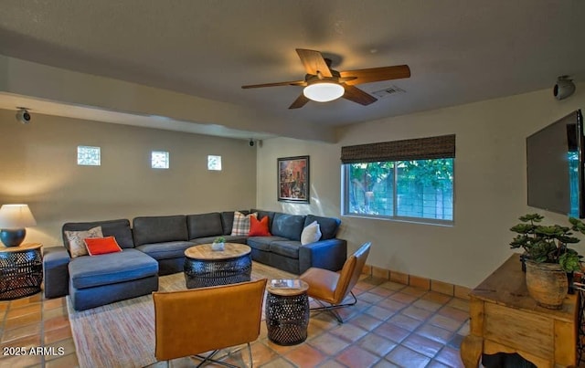 tiled living area with visible vents, a ceiling fan, and baseboards