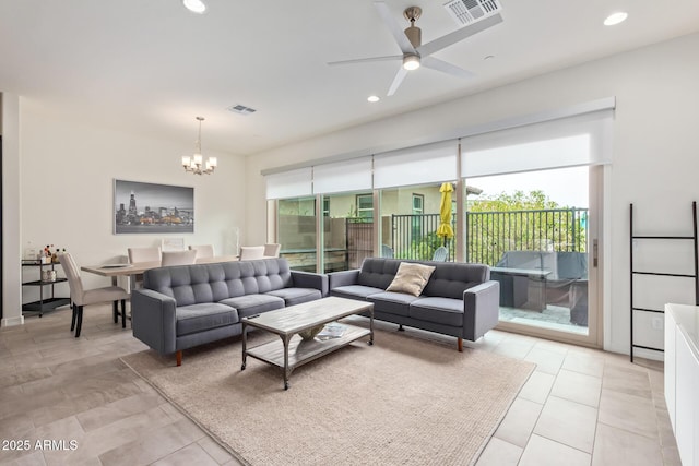 tiled living room with ceiling fan with notable chandelier