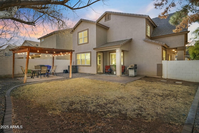 back house at dusk featuring a yard, a pergola, a patio, and central AC unit