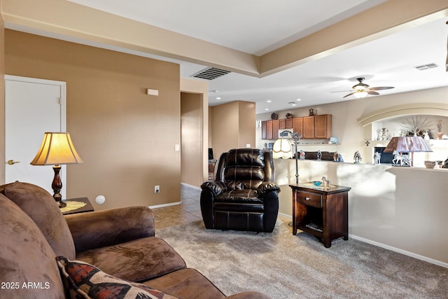 living room with visible vents, light carpet, baseboards, and a ceiling fan