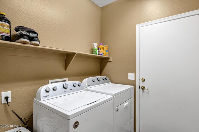 laundry room featuring washer and dryer, laundry area, and a textured wall