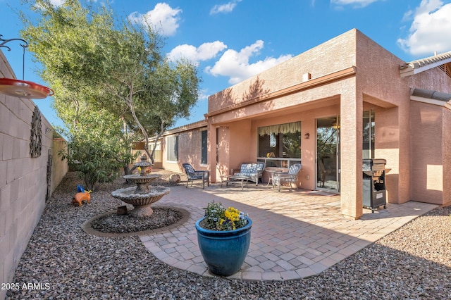 back of house with an outdoor living space, stucco siding, a fenced backyard, and a patio area