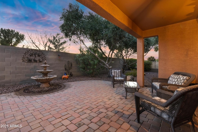 patio terrace at dusk with a fenced backyard