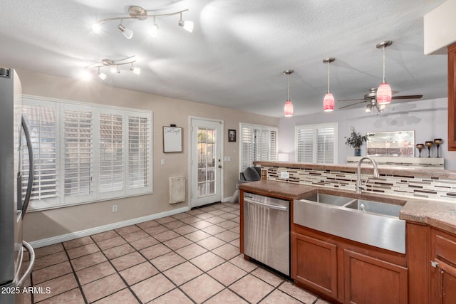 kitchen with sink, pendant lighting, ceiling fan, stainless steel appliances, and backsplash