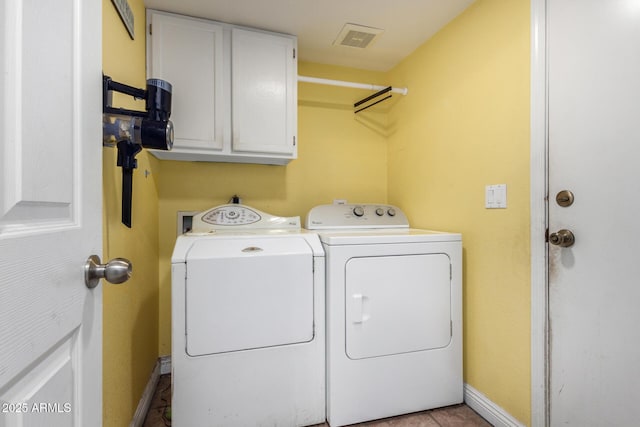 clothes washing area with cabinets, washer and clothes dryer, and light tile patterned floors