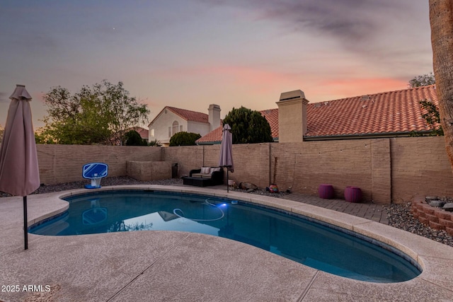 pool at dusk featuring a patio area