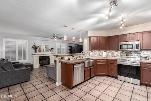 kitchen featuring pendant lighting, stainless steel appliances, sink, and decorative backsplash