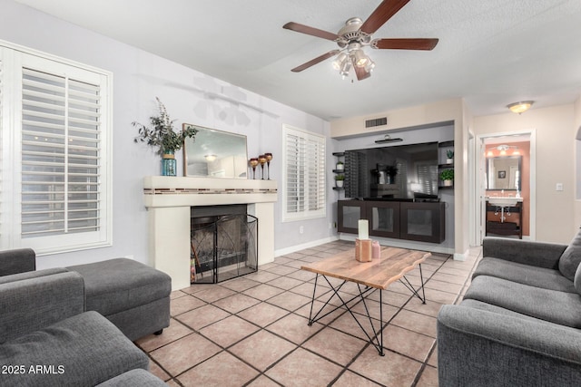 living room featuring sink, ceiling fan, and light tile patterned flooring