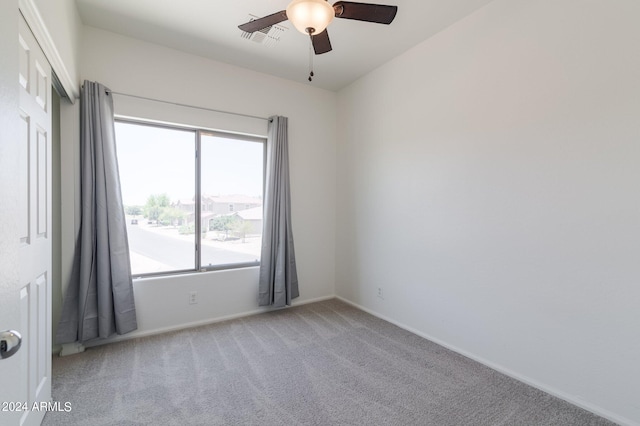 carpeted spare room featuring ceiling fan