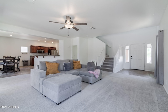 carpeted living room with ceiling fan